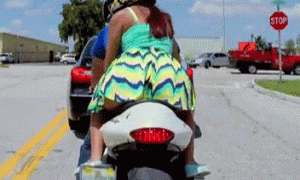 Сидит сзади на мотоцикле задирает платье гиф
