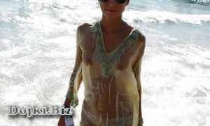 Худая девушка на пляже в мокрой накидке светится грудь фото