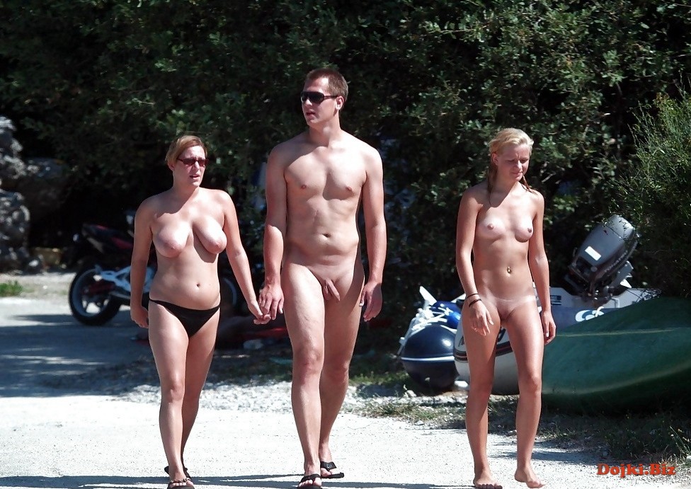 Две голые девушки и парень идут на нудистский пляж