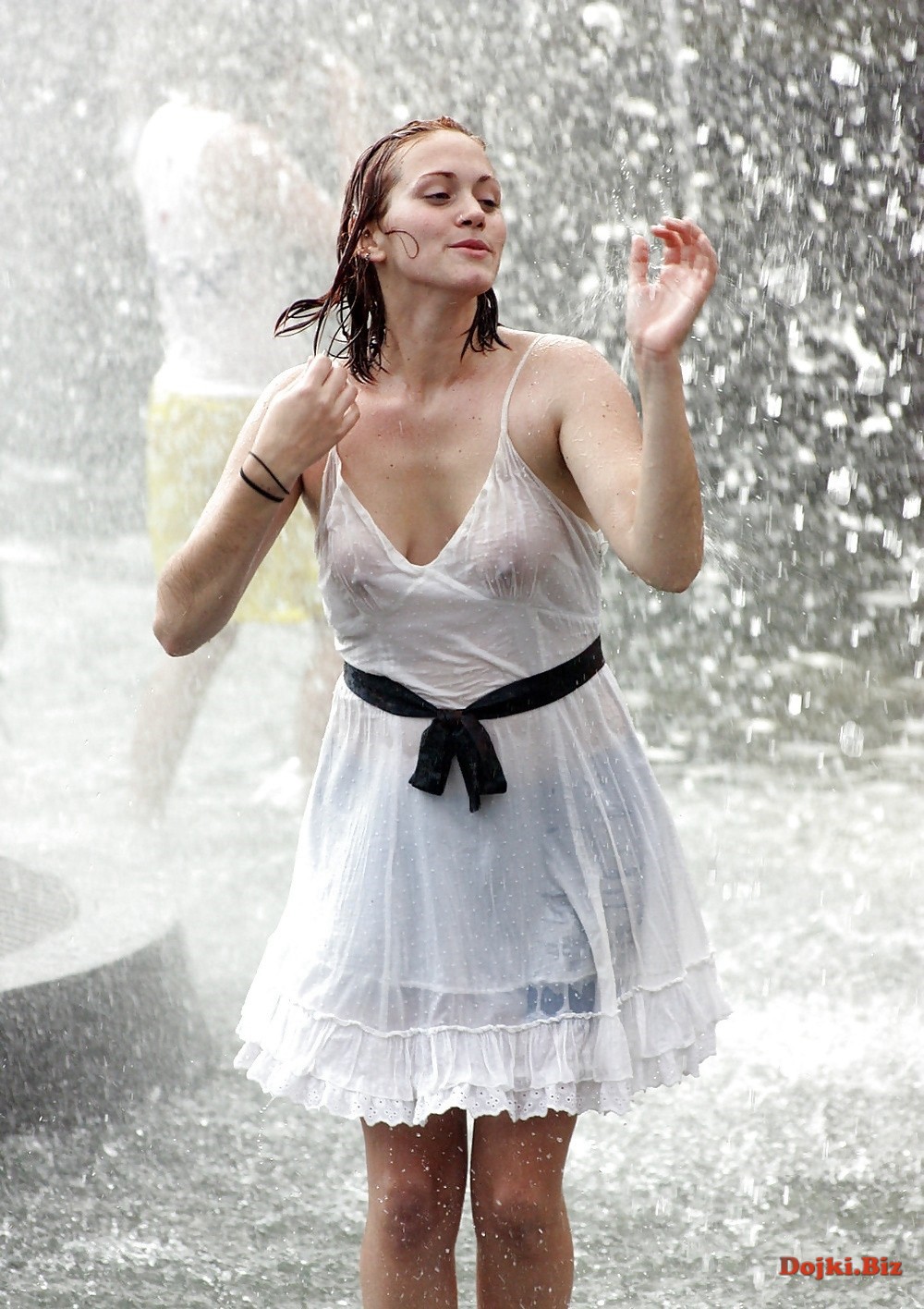 Мокрая в белом платье красотка под фонтаном