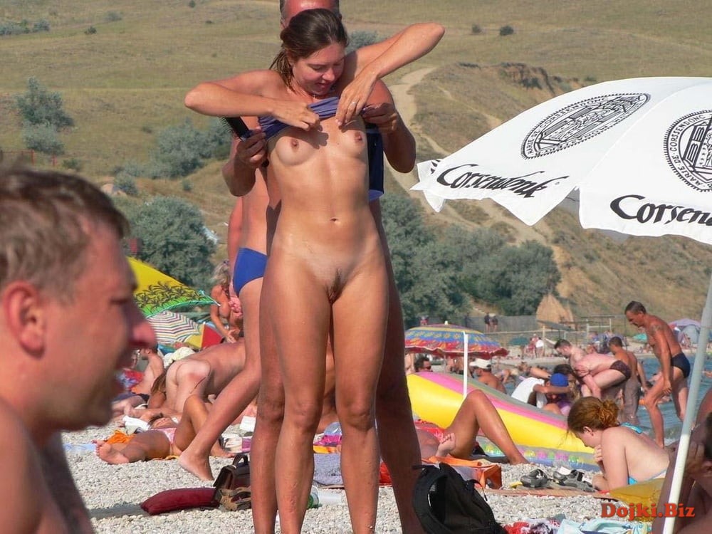 Мужик раздевает свою подругу на нудистском пляже
